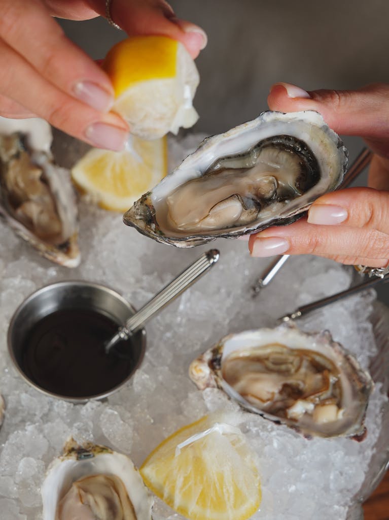 Close-up of fresh oysters on ice with lemon, ready to be served.